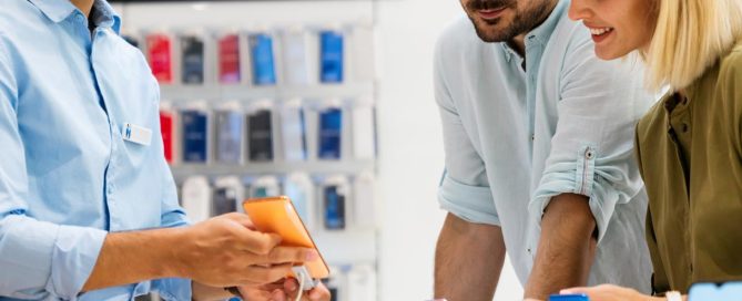 expert helping customers choose a mobile phone in tech store