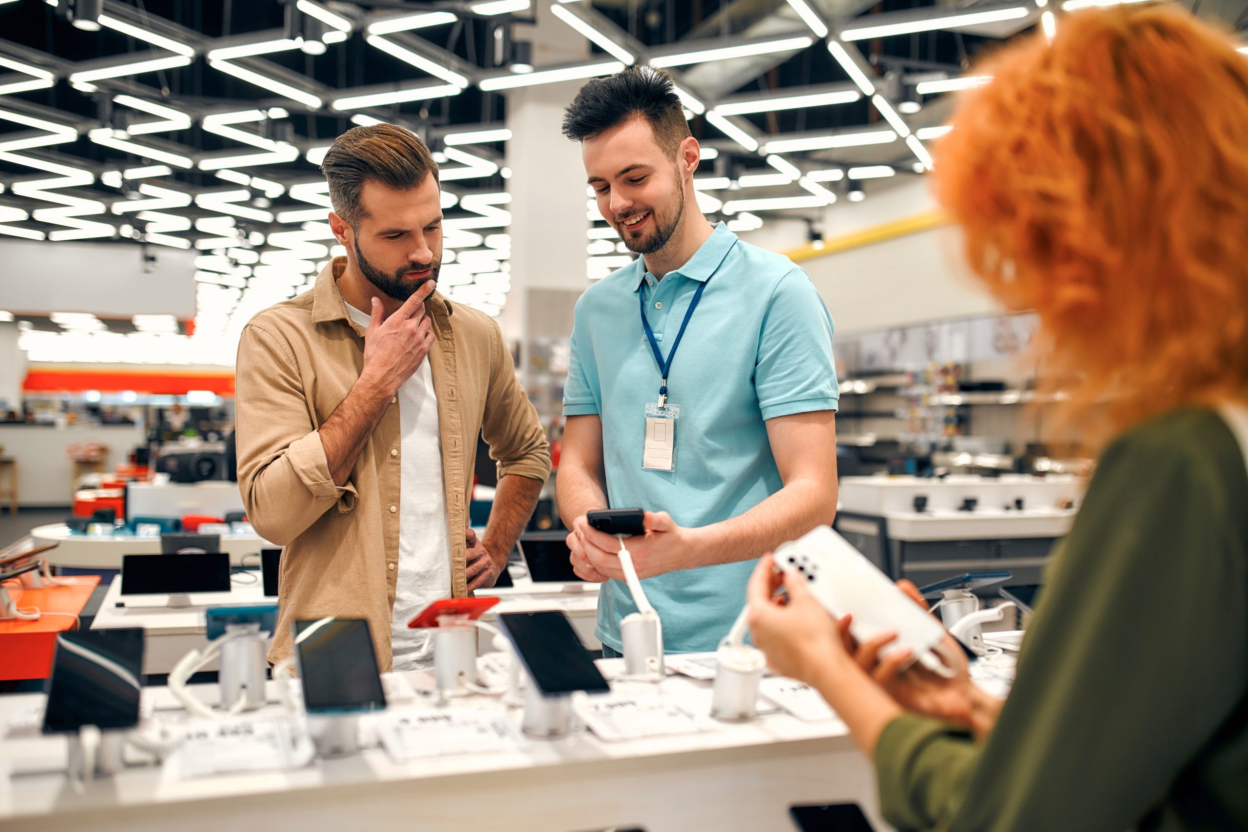 Sales,Consultant,Advises,Man,Who,Chooses,New,Smartphone,In,Store